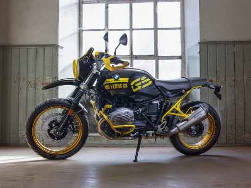 BMW R nineT 40 Years GS Sondermodell in Schwarz und Gelb vor großem Industriefenster.