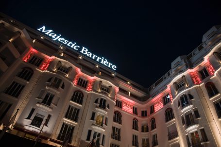 Hôtel Majestic Barrière in Cannes bei Nacht mit beleuchteter Fassade.