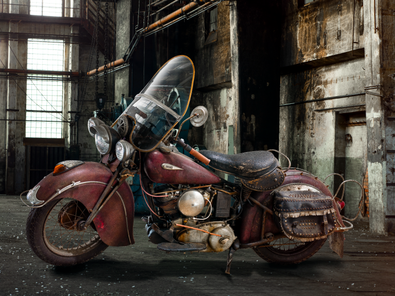 Indian Sport Scout von 1940 mit Roadmaster-Vollausstattung in einer historischen Industriehalle fotografiert.
