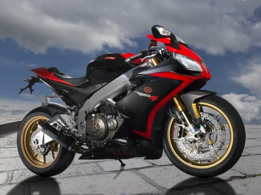 Aprilia RSV4 Baujahr 2015 in Schwarz-Rot mit goldenen Rädern vor dramatischem Wolkenhimmel.