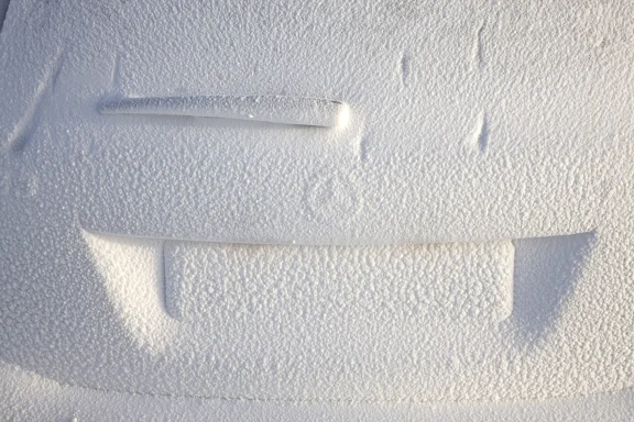 Heck eines Mercedes-AMG vollständig mit Schnee bedeckt, sichtbar sind nur Scheibenwischer und Kennzeichenkontur.
