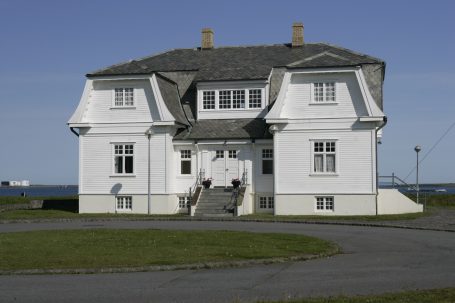Höfði-Haus in Reykjavík mit weißer Fassade und Blick auf das Meer.