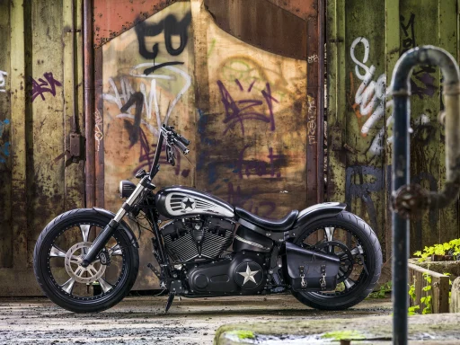 Custom Harley-Davidson FXSB Breakout von 2013 mit Military-Lackierung und Apehanger-Lenker vor Graffiti-Wand.