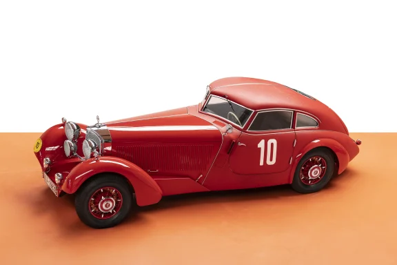 Schrägansicht von vorn eines roten Mercedes-Benz 540 K Stromlinien-Coupés mit aerodynamischer Karosserie vor neutralem Hintergrund.