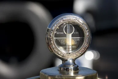 Nahaufnahme eines historischen Kühlwasserthermometers auf dem Kühlerdeckel eines klassischen Automobils.