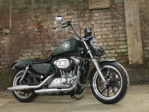 Harley-Davidson Super Glide von 2013 in mattem Olivgrün mit Military-Design. Professionell fotografiert vor einer historischen Backsteinwand