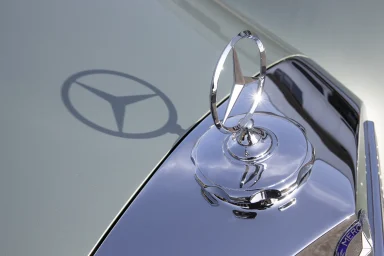 Mercedes-Benz Stern auf der Motorhaube mit Schattenwurf auf den Lack.
