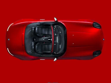Roter BMW Z8 Roadster in der Draufsicht auf rotem Untergrund mit geöffnetem Verdeck und schwarzer LederausstattungLederausstattung.