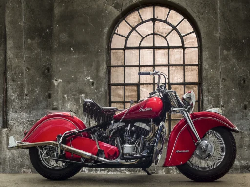 Indian Chief Model 347 Baujahr 1947 in roter Lackierung vor historischer Industriekulisse.
