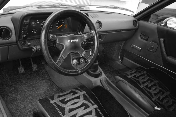 Innenraum eines Irmscher Manta i300 mit sportlichem Cockpit, Dreispeichenlenkrad und charakteristischen Sportsitzen.