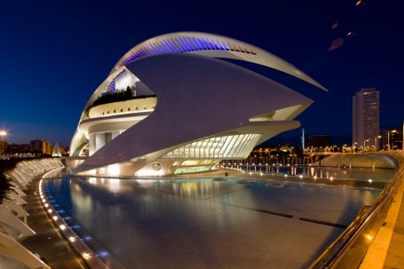 Oper von Valencia bei Nacht, beleuchtet am Wasser.