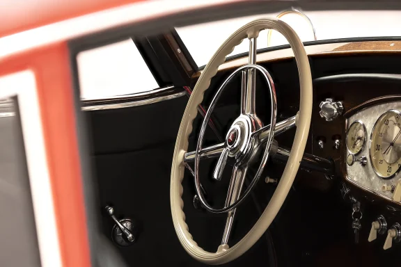 Detailansicht des cremefarbenen Lenkrads und des edlen Cockpits eines Mercedes-Benz 540 K mit Holzarmaturen und klassischen Instrumenten.