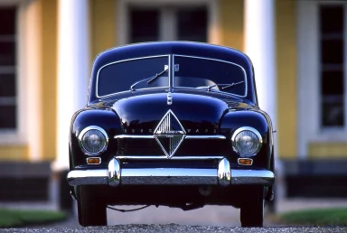 Schwarzes Oldtimer-Auto vor einem historischen Gebäude.
