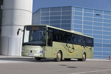 Mercedes-Benz Intouro Linienbus steht vor einem modernen Gebäude mit Glasfassade.