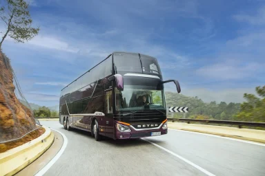 Setra S 531 DT Doppelstockreisebus fährt auf einer kurvenreichen Bergstraße durch eine hügelige Landschaft.