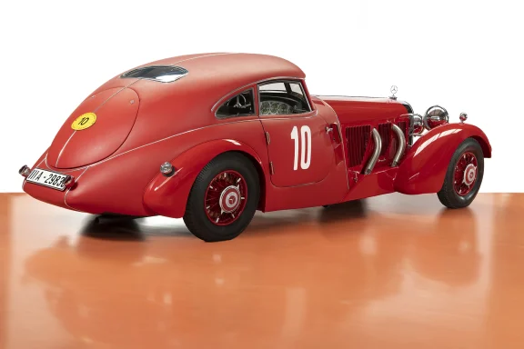 Schrägansicht von hinten eines roten Mercedes-Benz 540 K Stromlinien-Coupés mit markanter Stromlinienkarosserie im Studio.