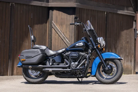 Harley-Davidson Heritage Classic 114 FLHCS in Schwarz und Blau mit Speichenrädern, Windschild und Lederkoffern.