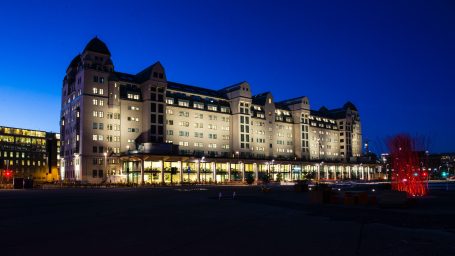Grand Hotel Oslo bei Nacht mit beleuchteter Fassade und markantem Uhrturm.