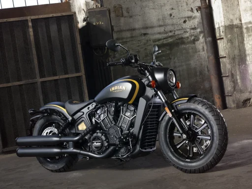 Indian Scout Bobber mit V2-Motor in mattschwarzer Lackierung vor historischer Industriekulisse.