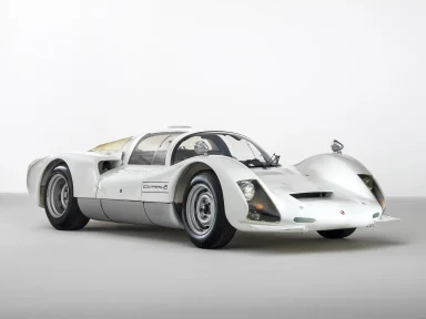 Weißer Porsche 906 Carrera 6 in Dreiviertelansicht auf hellem Studiohintergrund.