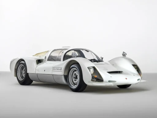 Weißer Porsche 906 Carrera 6 in Dreiviertelansicht auf hellem Studiohintergrund.