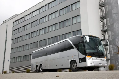 Weißer Setra S 417 TC Reisebus steht vor einem modernen mehrstöckigen Bürogebäude.