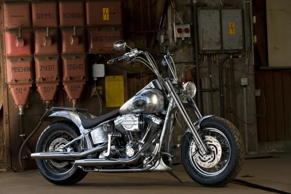 Harley-Davidson Softail FXST Baujahr 2002 mit gravierter Sonderlackierung und Apehanger-Lenker in einer Industriehalle.