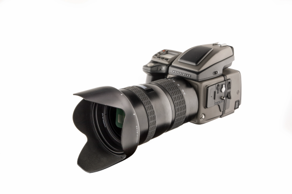 Hasselblad Mittelformatkamera HD50 mit angesetztem Objektiv und Gegenlichtblende als freigestellte Produktaufnahme auf hellem Hintergrund.