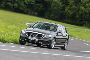 Mercedes-Benz T-Modell (S205) auf einer kurvenreichen Landstraße in grüner Landschaft.