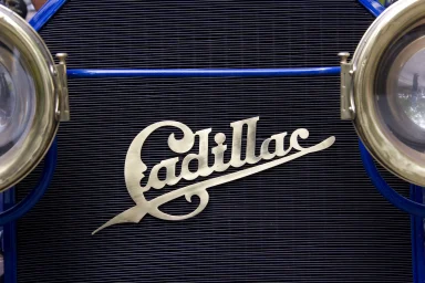 Nahaufnahme des Cadillac-Emblems am Kühlergrill eines historischen Fahrzeugs.
