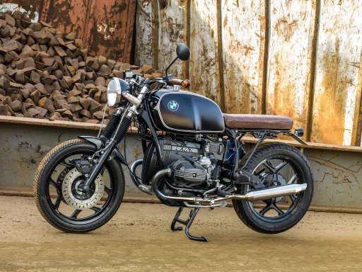 Schwarzer BMW R80 Café Racer mit Boxermotor vor einer Industriekulisse.
