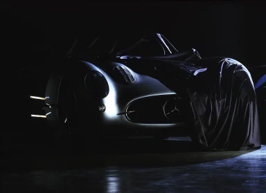 Inszenierte Studioaufnahme des Mercedes-Benz 300 SLR Uhlenhaut Coupé mit dramatischer Lichtführung und teilweiser Verhüllung.