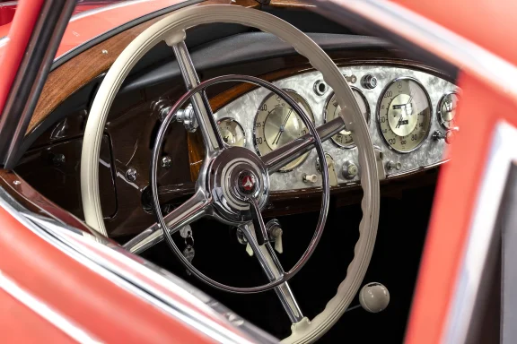 Blick in das Cockpit eines Mercedes-Benz 540 K mit elegantem Lenkrad, Holzarmaturenbrett und klassischen Rundinstrumenten.