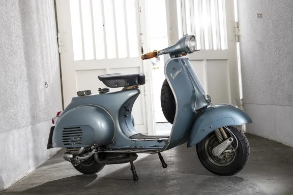 Blaue Vespa 150 VBB1T Baujahr 1961 mit authentischer Patina in einer historischen Durchfahrt.