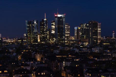 Frankfurter Skyline bei Nacht mit beleuchteten Hochhäusern.