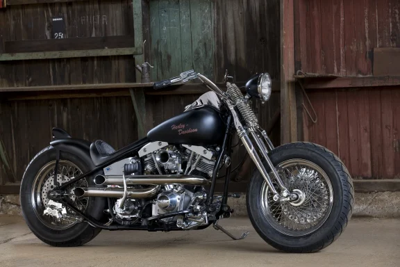 Harley-Davidson Custom-Chopper mit Starrahmen, Shovelhead-Motor und Springer-Gabel in einer historischen Industriehalle.