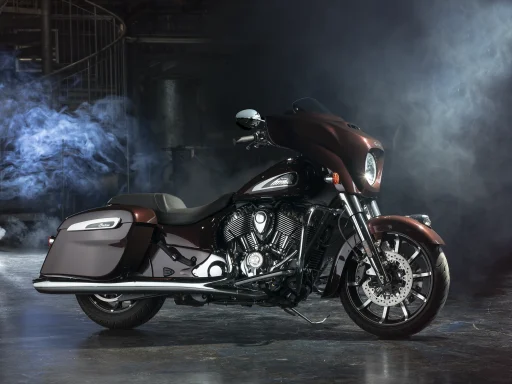 Indian Chieftain Limited in Crimson Metallic vor stimmungsvoller Industriekulisse.
