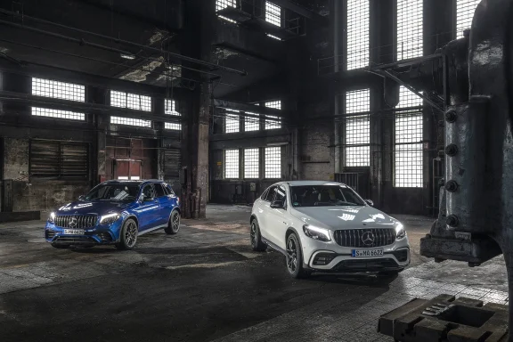 Zwei Mercedes SUV, ein blauer und ein weißer SUV, stehen in einer alten Fabrikhalle.