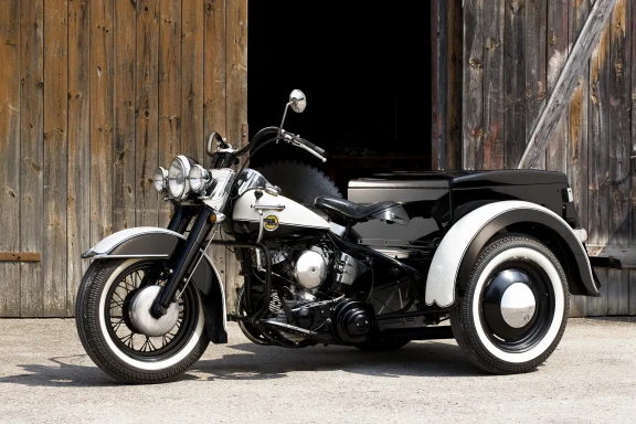 Harley-Davidson VLH Dreirad von 1933 in Schwarz-Creme vor historischer Holzscheune.