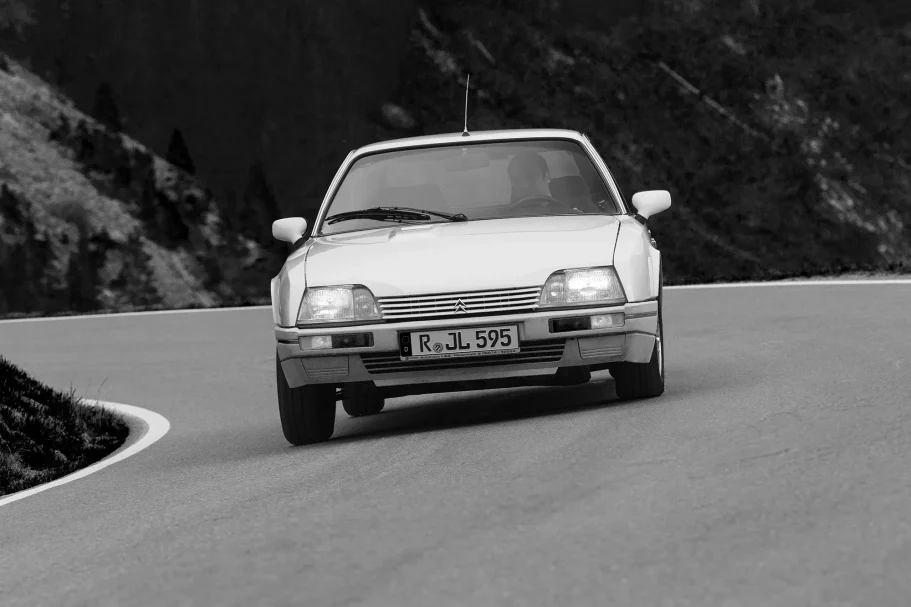 Citroën CX 25 GTI Turbo in Schwarzweiß bei einer dynamischen Kurvenfahrt auf einer Alpenstraße.
