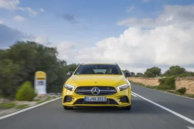 Gelber Mercedes-AMG A 35 4MATIC in Frontansicht auf einer Landstraße.