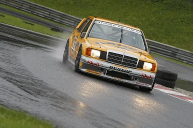 Mercedes-Benz 190 E Rennfahrzeug auf regennasser Rennstrecke – dynamische Motorsportfotografie von Dieter Rebmann.