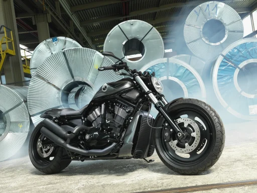 Harley-Davidson Shelby Rod VRSC Baujahr 2011 in Mattschwarz vor großen Stahlcoils in einer Industriehalle, professionell fotografiert.