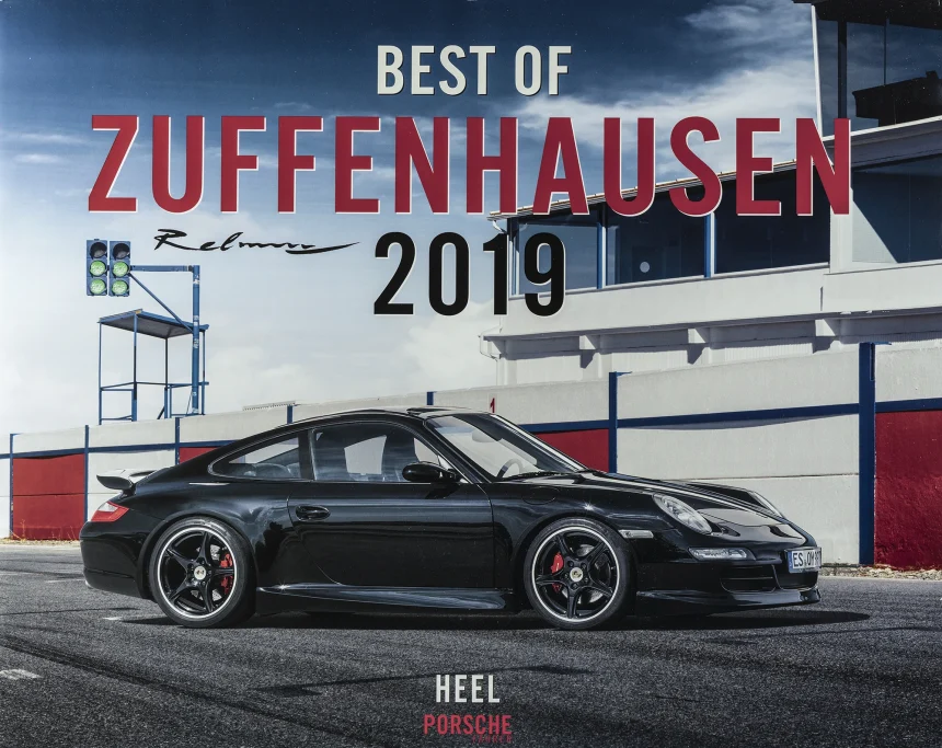 Titel des Porsche-Kalenders „Best of Zuffenhausen 2019“ mit schwarzem Porsche 911 (997) auf einer Rennstrecke vor den Boxengebäuden.
