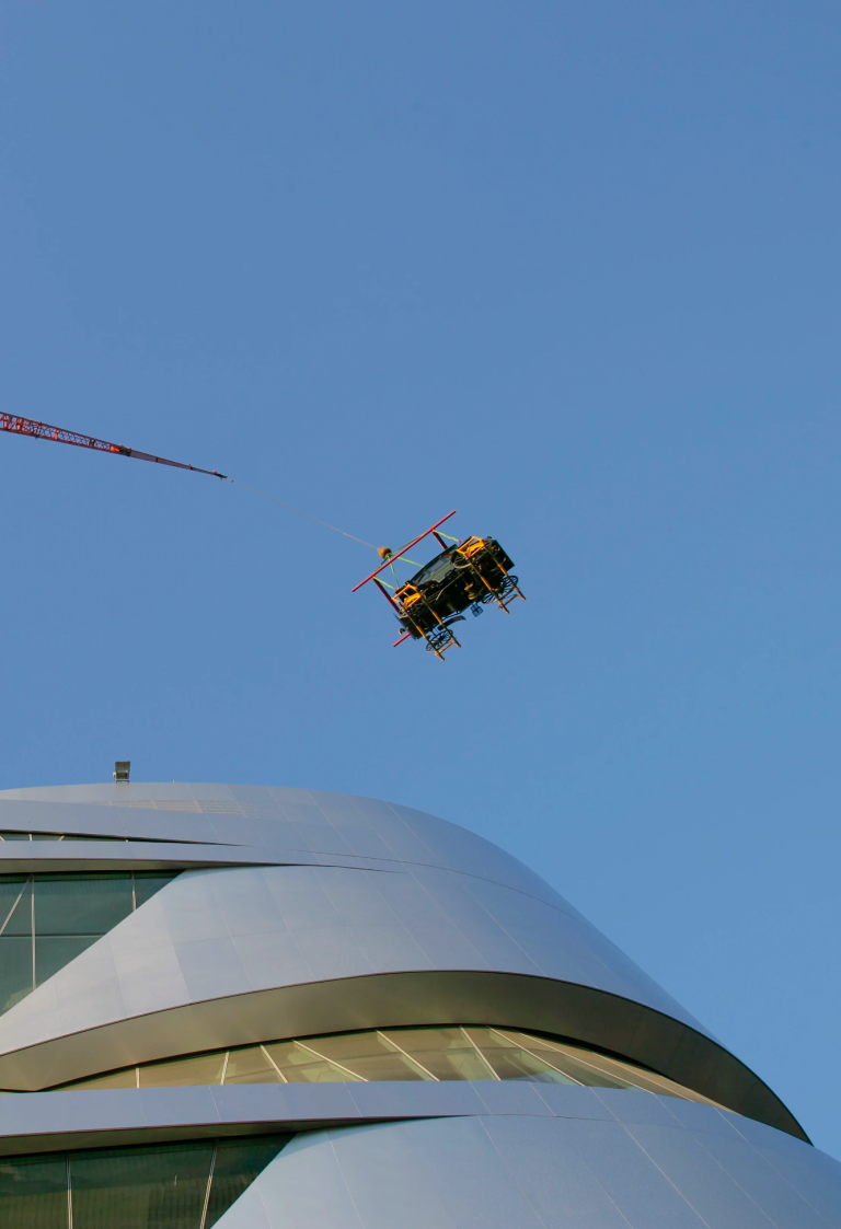 Mercedes-Benz Museum – Fahrzeugeinbringung in Ebene 8 Historisches Fahrzeug wird per Kran von außen in Ebene 8 des Mercedes-Benz Museums eingebracht.