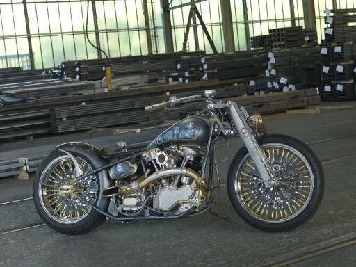 Royal Treasure Custombike mit Airbrush-Lackierung, vergoldeten Details und filigranen Speichenrädern, fotografiert in einer Industriehalle.