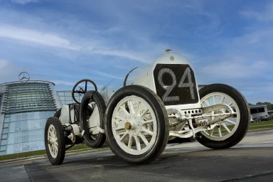 Ein historisches Rennwagenmodell mit der Nummer 24 vor modernem Hintergrund.