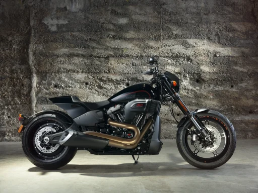 Schwarze Harley-Davidson FXDR 114 mit Milwaukee-Eight-Motor vor einer Betonwand in einer historischen Industriehalle fotografiert.
