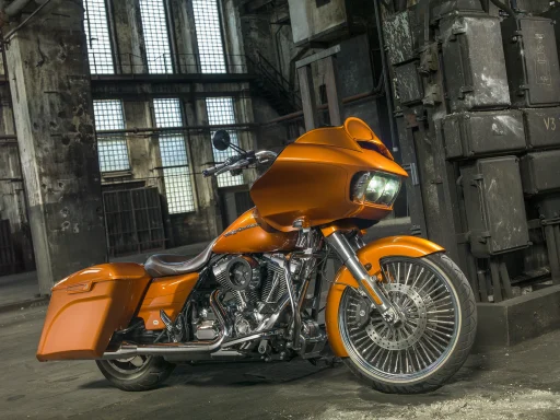 Orange Harley-Davidson Road Glide Custom mit großem Vorderrad in einer Industriehalle, professionell fotografiert.