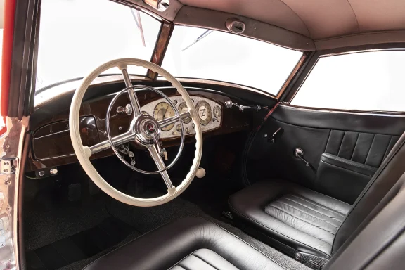 Innenansicht des Mercedes-Benz 540 K mit luxuriösem Cockpit, klassischem Lenkrad, Holzarmaturenbrett und schwarzen Ledersitzen.